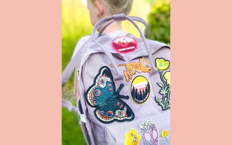 Embroidered patches offer a textured, classic look that adds a touch of artistry to any backpack