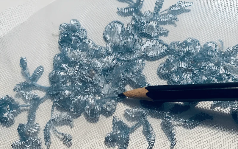 Building custom lace designs can be done by stitching lace appliques onto a base fabric