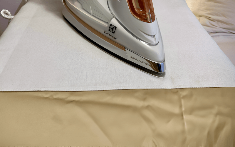Lay a slightly damp cloth (cotton or linen) over the wrinkled area and iron over the cloth