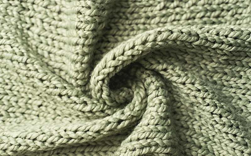 In contrast to the structured grid of woven fabrics, knit fabrics are created by interlooping yarns in a series of connected loops