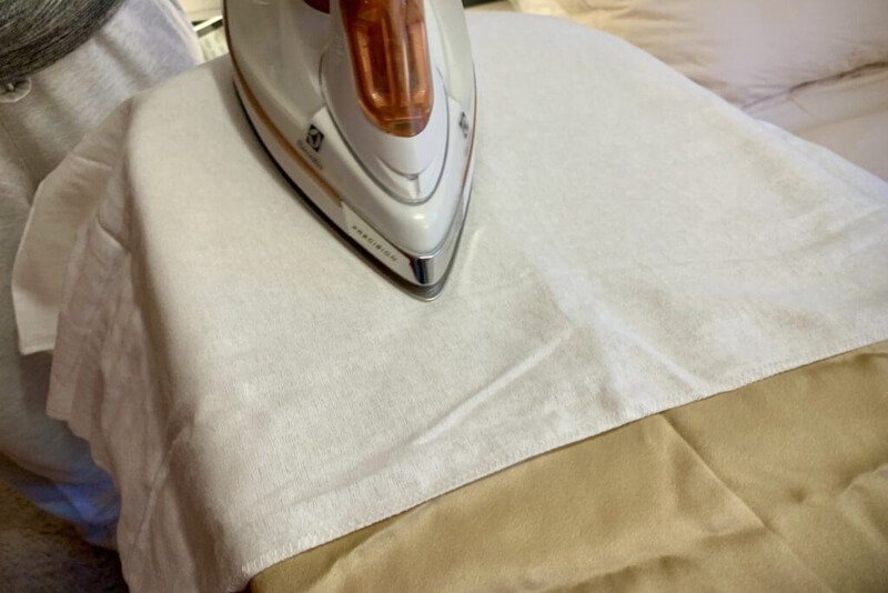 Hands smoothing clean, dry fabric, ready for rhinestone embellishment project.