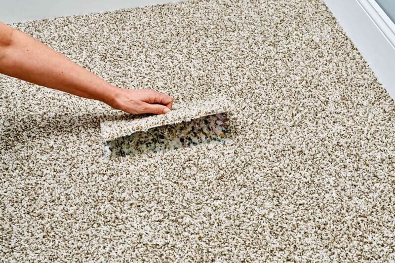 Fitting a replacement carpet patch carefully.