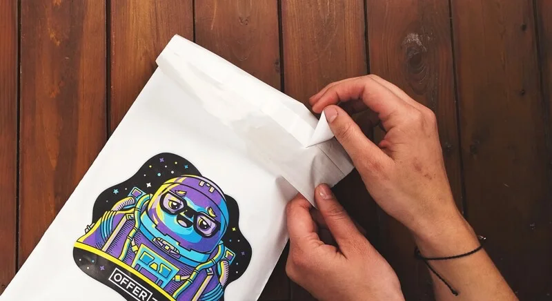Hands sealing a poly mailer with a self-adhesive strip