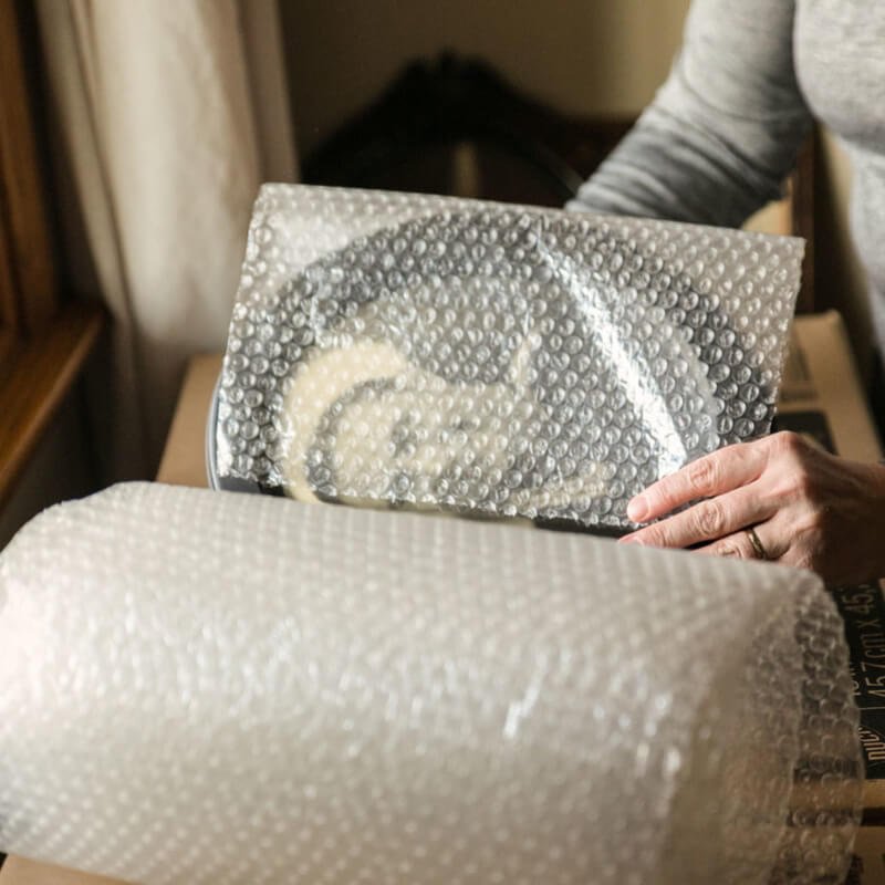 Bubble-wrapped fragile item placed inside a poly mailer