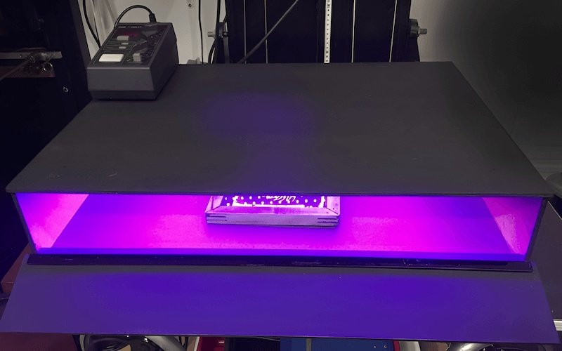 UV light hardens the emulsion, except where blocked by the film positive design.