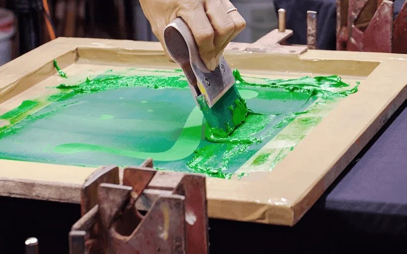 A squeegee is moved across the screen with consistent pressure.