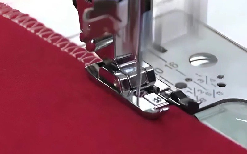 This is an overlock machine. Its main job is to finish the edges of fabric, making them look neat and stopping them from fraying