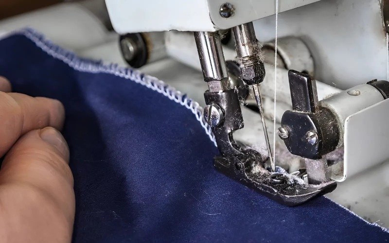 Overlocks wrap edges with multiple threads via loopers, while regular machines use a bobbin (a small spool below) for their stitches