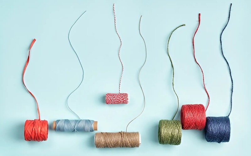 The way tiny fibers are twisted together to form thread also affects how it feels and sews